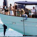 Queen's Roger Taylor uses a pole and shoots an AIRGUN at jellyfish whilst on a boat ride with his wife and children during sun-soaked holiday in Spain, 31 May 2019