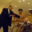 A healing preacher (Lance E. Nichols, left) seeks to help Benjamin (Robert Towers, sitting) who has been brought to the convocation by Queenie (Taraji P. Henson, center) in 'The Curious Case of Benjamin Button.' Photo Credit: Digital Domain. Copyr