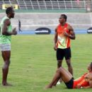 Jamaican runners (L-R) Usain Bolt, Yohan Blake and Warren Weir talk after running in the men's 400m race of the Camperdown Classic, an annual track event in its ninth year, in Kingston February 9, ..