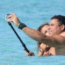 Retired footballer Ronaldo uses a selfie stick to take loved up holiday snaps in the sea with beach babe fiancé Paula Morais