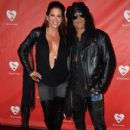 Musician Slash (R) and Perla Hudson attend the MusiCares MAP Fund Benefit Concert at Club Nokia on May 12, 2014 in Los Angeles, California - 410 x 594