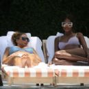 Larsa Pippen – With Kiki Barthlook in bikinis as they sit by the pool in Miami - 454 x 303