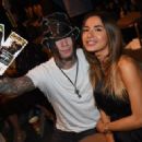 Guitarist Dj Ashba (L) of Guns N Roses and his wife, model Nathalia Henao, attend the UFC 175 event at the Mandalay Bay Events Center on July 5, 2014 in Las Vegas, Nevada - 454 x 323