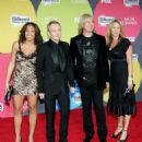 Musician Phil Collen (2nd from left) with wife Anita (L), Joe Elliott (2nd from right) with wife Kristine arrive at the 2006 Billboard Music Awards at the MGM Grand Garden Arena December 4, 2006 in Las Vegas, Nevada.