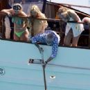 Queen's Roger Taylor uses a pole and shoots an AIRGUN at jellyfish whilst on a boat ride with his wife and children during sun-soaked holiday in Spain, 31 May 2019 - 306 x 479
