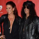 Musician Slash (R) and Perla Hudson attend the MusiCares MAP Fund Benefit Concert at Club Nokia on May 12, 2014 in Los Angeles, California - 445 x 594