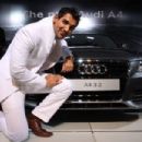 John Abraham poses with the new Audi A4 , during its launch at Auto Expo