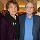 Social butterfly: Mick posed with American businessman, Paul Allen, as he casually slung a black scarf around his shoulders