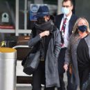 Catherine Zeta-Jones is stylish in a fedora and Gucci belt as she arrives at JFK Airport with husband Michael Douglas