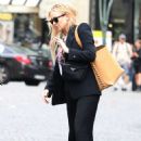 Kate Hudson wears a chic black suit worn over a vintage MTV T-shirt as she leaves Paris