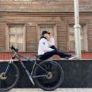 Viola Bailey (Violeta Jurgis Arturovna) in cycling gear in front of her childhood home - Instagram - May 11, 2020