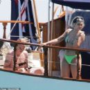 Queen's Roger Taylor uses a pole and shoots an AIRGUN at jellyfish whilst on a boat ride with his wife and children during sun-soaked holiday in Spain, 31 May 2019 - 454 x 379