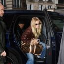 Gigi Hadid – Wearing a Holzweiler brown jacket paired with Adidas sneakers in Paris