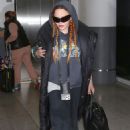 Madonna wore a grey undershirt and a graphic dark grey hoodie at JFK airport in NY