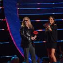 Vince Neil and Sara Evans present an award onstage at the 2014 CMT Music Awards at Bridgestone Arena on June 4, 2014 in Nashville, Tennessee. - 419 x 594