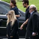 Josh Duhamel and Fergie look somber as they leave a funeral service