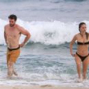 Gabriella Brooks in Black Bikini and Liam Hemsworth on the beach in Byron Bay - 454 x 328
