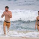Gabriella Brooks in Black Bikini and Liam Hemsworth on the beach in Byron Bay - 454 x 329