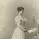 Photograph of Princess Victoria Melita of Saxe-Coburg and Gotha standing facing right holding an open fan.