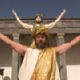 King Philip (Val Kilmer) walks into the amphitheatre to have himself enshrined as the 13th god of the Greek pantheon.